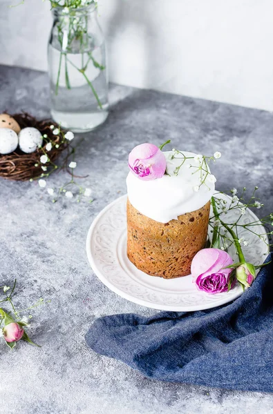 Paskalya kek kulich. Geleneksel Paskalya tatlı ekmek beze ve gri taş tablo arka plan üzerinde plaka üzerinde pembe gül dekore edilmiştir. Kopya alanı.