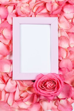 Gül yaprakları ve fotoğraf çerçevesi ile Sevgililer günü tebrik kartı. Mockup kavramı ile metin için yer
