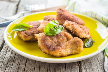 Ev yapımı dilimlenmiş Wiener tavuk Schnitzel ahşap masa arka plan üzerinde plaka üzerinde.