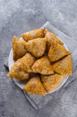 Lezzetli samosas samsa etli gri arka plan, üstten görünüm ile plaka. Özbek gıda