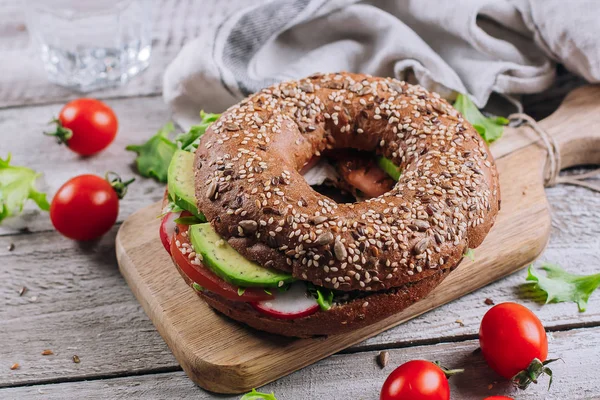 Simit krem, avokado, domates, turp ve yeşil ahşap tahta ve tablo arka planda kalıyor. Sağlıklı kahvaltı yemek. Lezzetli dengeli gıda kavramı. Üstten Görünüm ve kopya alanı