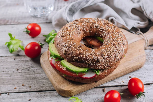Simit krem, avokado, domates, turp ve yeşil ahşap tahta ve tablo arka planda kalıyor. Sağlıklı kahvaltı yemek. Lezzetli dengeli gıda kavramı. Üstten Görünüm ve kopya alanı