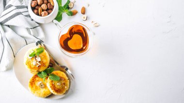 Kahvaltı veya öğle yemeği konsepti. Beyaz arka planda ballı, fındıklı ve naneli süzme peynirli krep. Üst görünüm, pankart resmi