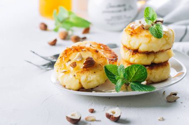 Kahvaltı yemek lezzetli kavramı. Süzme peynirli gözleme, syrniki, bal ile lor börek ve kulübe beyaz masa arka plan beton. Yakın çekim