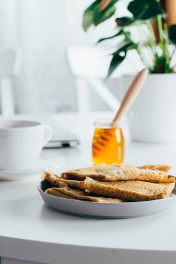 Lezzetli Breakfast. Dizüstü bilgisayar ve taze gözlemeler beyaz masaüstü tablo krep, fincan çay ve bal kavanozu. Freelancer kavramı. Sağlıklı kahvaltı gıda.