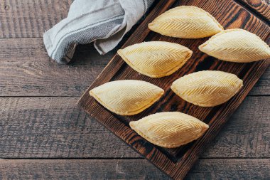 Azerbaycan Ulusal tatlı. Oriental tatlı pasta tatlı - ahşap masa arka plan üzerinde ahşap tahta üzerinde Shekerbura. Üstten Görünüm, kopya alanı
