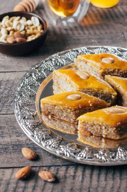 Baklava. Ramazan tatlısı. Fındık ve bal, ahşap masa arka plan üzerinde çay ile geleneksel Arapça tatlı. Yakın çekim