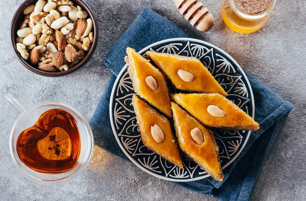 Baklava. Sobremesa Ramadan. Sobremesa árabe tradicional com nozes e mel, xícara de chá em uma mesa de concreto. Vista superior — Fotografia de Stock