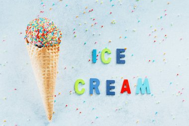 Dondurma külah ile sprinkles. Lezzetli tatlı dondurma, nefis lezzetli tedavi. Yaz kartı üst görünümü, kopya alanı. Mavi arka plan