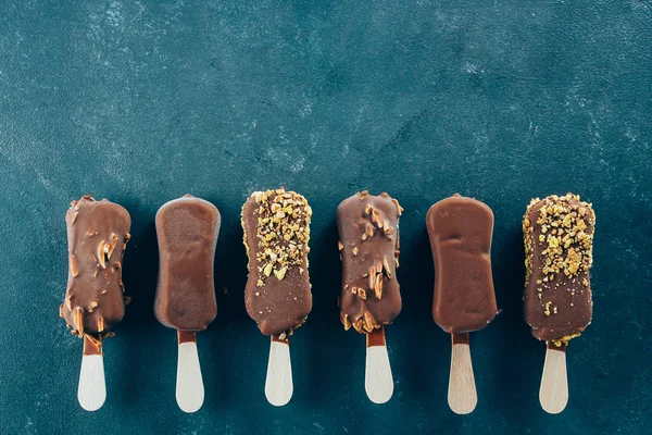 Eskimo dondurmanın içine mavi zemin üzerine çikolata sır. Lezzetli tatlı gıda aperatif tedavi. Üstten Görünüm, kopya alanı