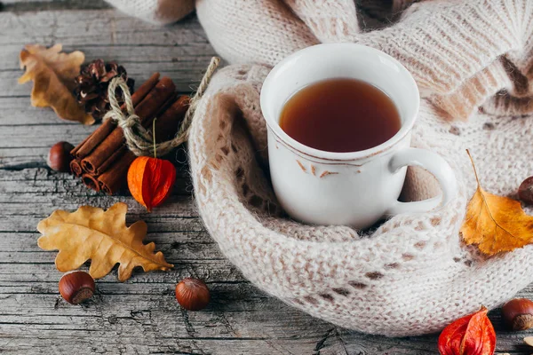 Теплий в'язаний светр і чашка гарячого чаю на дерев'яному дошці столу — стокове фото