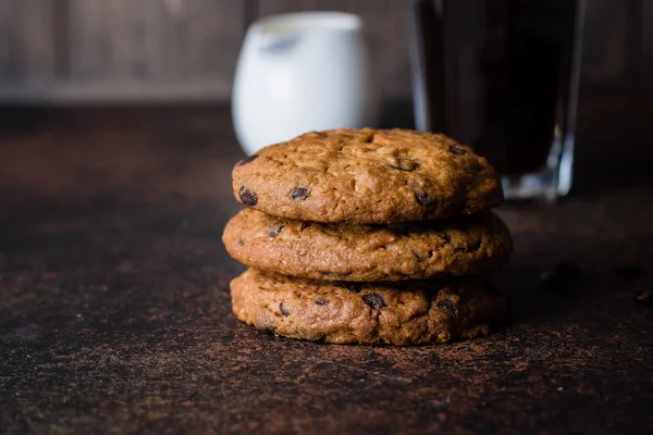 Coffee glass and milk with chocolate chip cookie on dark stone concrete table background. Morning Breakfast Concept. Copy space — Stock Photo, Image