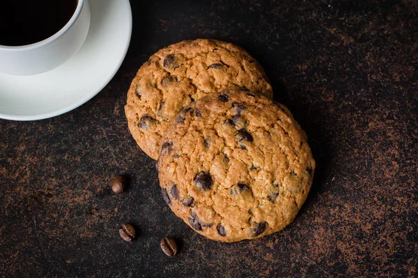 Coffee glass and milk with chocolate chip cookie on dark stone concrete table background. Morning Breakfast Concept. Copy space — Stock Photo, Image
