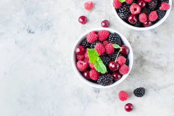 Summer fresh berries in white bowl on gray concrete table background. Top view with copy space. Vegetarian food - raspberry, blackberry and cherry — Stock Photo, Image