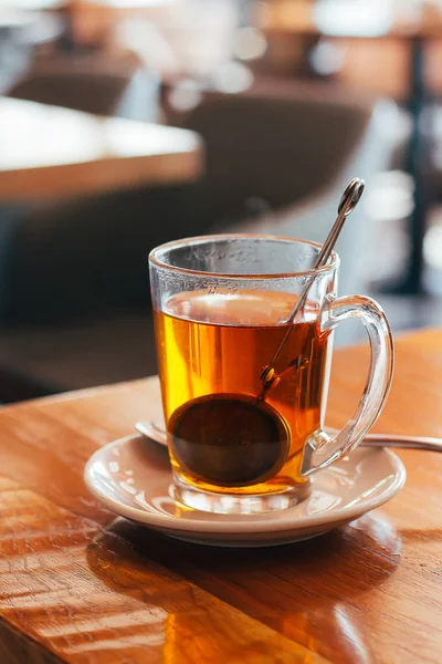 Glas mugg med hett te på ett kafé med suddig bakgrund. Naturligt ljus — Stockfoto