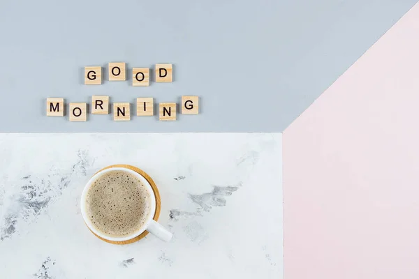 God morgon frukost minimal koncept. Kopp kaffe och text god morgon skriftligen med trä bokstäver på tricolor bakgrund. Flat Lay, kopiera utrymme, uppifrån — Stockfoto