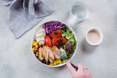 Kadın sağlıklı öğle yemeği yiyor. Tavuk, yumurta ve domatesli kase.,