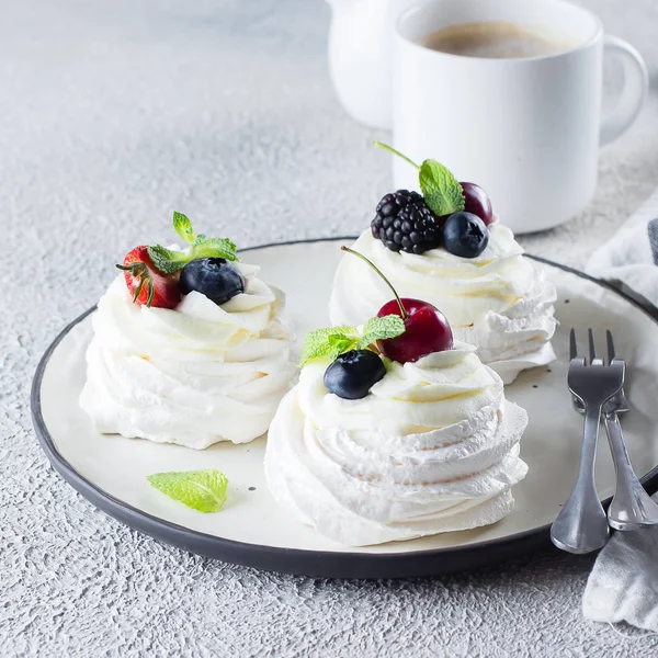 Moučník Pavlova koláč s čerstvými plody na talíři a šálku kávy. Kamenné pozadí, zblízka — Stock fotografie