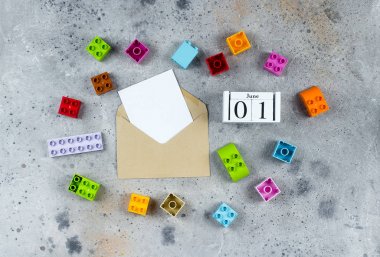 Çocuk Bayramınız kutlu olsun. Ahşap küpler takvim tarihi 1 Haziran ve gri arka plan üzerinde renkli plastik küpler. Creative Top view Flat lay Şablonu