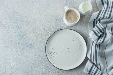 Açık seramik tabak, kahve fincanı ve mutfak çizgili havlu açık taş beton masa arka plan. Kopya alanı. Menü Tarifi Kavramı. Üst te. Düz yatıyordu