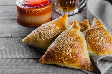 Et ile lezzetli samosas samsa, ahşap masa arka planda çay bir bardak, üst görünüm. Doğu Asya yemeği. Ramazan yemeği