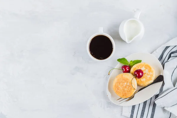 Летний завтрак с оладьями из творога, чашка черного кофе — стоковое фото