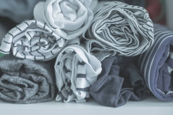 Marie Kondo με την έννοια της μεθόδου-διπλωμένα ρούχα. Άσπρα, γκρίζα, μπλε και ριγέ μπλουζάκια. Επιλεκτική εστίαση, τονισμένη εικόνα — Φωτογραφία Αρχείου