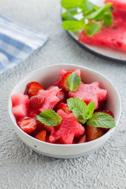 Beton arka plan masasında karpuz ve çilek ile yaz salatası