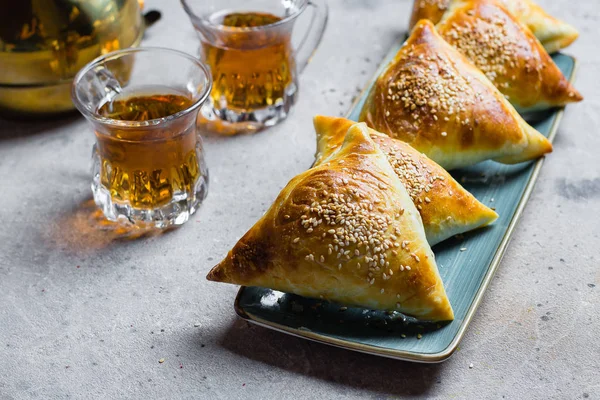 Et ile lezzetli samosas samsa, ahşap masa arka planda çay bir bardak, üst görünüm. Doğu Asya yemeği. Ramazan yemeği