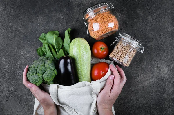 Zero waste concept. Female hands holding vegan vegetables in cot