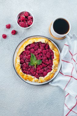 Hafif beton masa arka plan üzerinde kahve fincan ile ev yapımı ahududu açık pasta gallete. Üst görünüm, kopyalama alanı