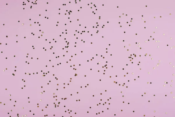 Golden sparkles estrelas no fundo da moda pastel rosa. Fundo festivo. Deitado plano, vista superior — Fotografia de Stock