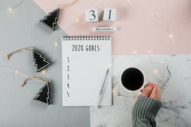 Mutlu Yıllar 2020. Bir fincan kahve tutan ve ferman tutan kadın eli
