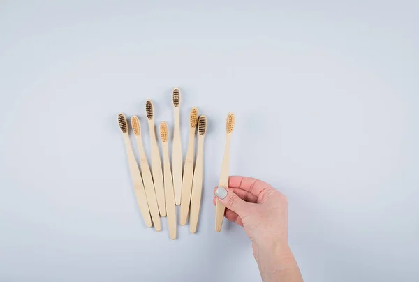 Vlakke lay compositie met bamboe tandenborstels op grijze achtergrond. Eco natuurlijke bamboe tandenborstels. Geen afval, plastic vrije items concept. Bovenaanzicht, kopieer ruimte — Stockfoto