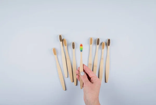 Vlakke lay compositie met bamboe tandenborstels op grijze achtergrond. Eco natuurlijke bamboe tandenborstels. Geen afval, plastic vrije items concept. Bovenaanzicht, kopieer ruimte — Stockfoto