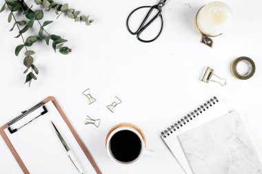 Ofis masası. Okaliptüs, pano, defter, kahve, makas, mum ve kalemle dolu bir işyeri. Düz konum, üst görünüm, model, kopyalama alanı. Günlük, blog yazarı, fırfırlayıcı kavramı