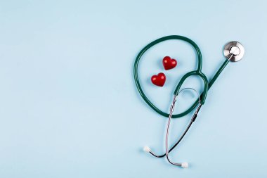 Ulusal Hemşire Günü Tatil Geçmişi. Tıbbi steteskop, iki kırmızı kalp ve ahşap harfler. Sağlık sigortası konsepti. Üst görünüm, düz görünüm, kopyalama alanı