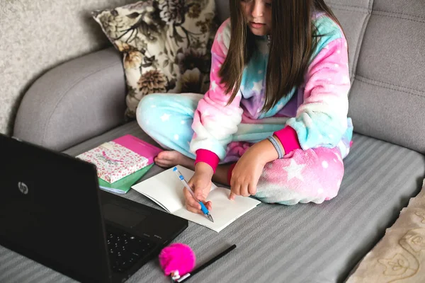 Schoolgirl studying at home using laptop. Home school, online education, home education, quarantine, coronavirus concept