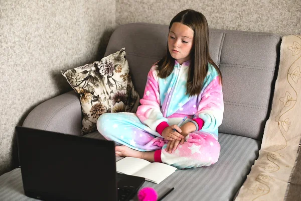 Schoolgirl studying at home using laptop. Home school, online education, home education, quarantine, coronavirus concept