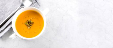 Beyaz kasede mermer masada balkabağı çorbası. Sonbahar mevsimlik çorba tabağı. Üst görünüm, alanı kopyala.