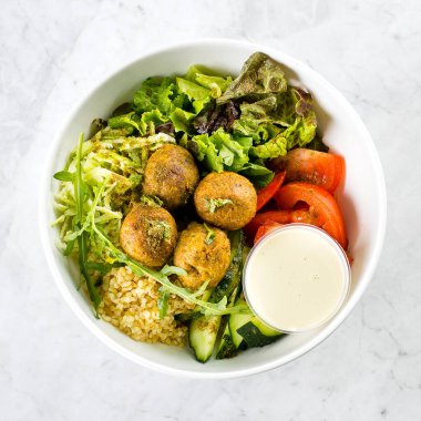 Falafel ve taze sebzeler beyaz mermer masa zemininde karışık salata, üst manzara. Vejetaryen, diyet gıda konsepti