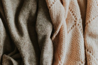 Yumuşak kahverengi ve bej tonlarda kumaş örülmüş kumaşların yakın çekimi, hassas desenleri ve dokuları aracılığıyla sıcaklığı ve konforu gösterir..