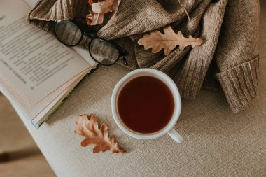 Sonbahardan esinlenilmiş daire, okuma gözlüğü, yün süveter, bir fincan kahve ve düşmüş yapraklar ile açık bir kitap sergilenerek sıcaklığı, rahatlığı ve mevsimsel rahatlığı çağrıştırıyor..