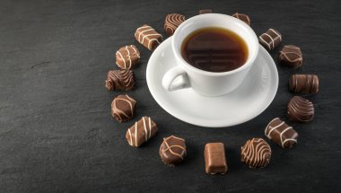 Doğal siyah taş zemin üzerine güzel yaratıcı çikolatalı tatlılar. Metin için yer ile yuvarlak kare şeklinde çikolata karışımı