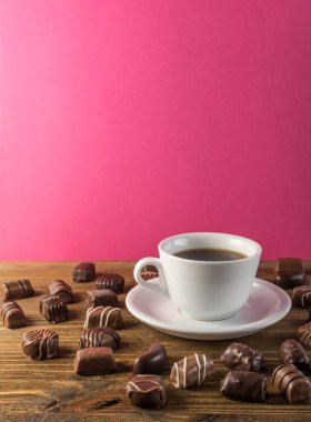 Ahşap arka plan üzerinde güzel yaratıcı çikolatalı tatlılar. Çikolata kahve fincanı ve pembe fon ile karışımı