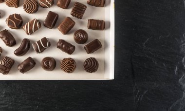 Doğal ahşap zemin üzerine çikolata şeker kutusu. Mix düz Lay ve çikolata üstten görünüm