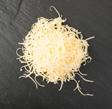 Siyah arka plan üzerine rendelenmiş peynir yığını. Yukarıdaki fotoğraf