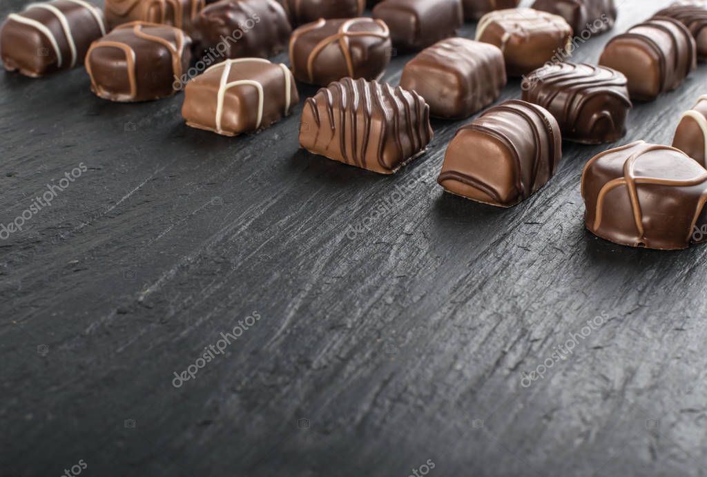 Hermosos dulces de chocolate creativos sobre fondo de piedra negra