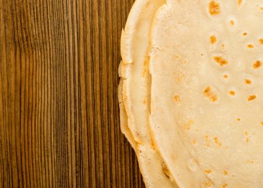 İnce krep veya ahşap masa arka plan üstten görünüm üzerinde Tortilla. Taze ev yapımı krep veya metin alanı olan Lay düz gözleme