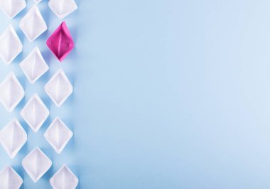 Bir benzersiz pembe kağıt tekne birçok olanlar arasında. Farklı kağıt gemiler yaratıcılık kavramı ve düşünün farklı olarak